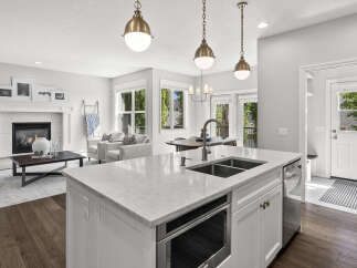 Experience modern living in this open-concept home featuring a gourmet kitchen with a large island, sleek countertops, and stainless steel appliances.