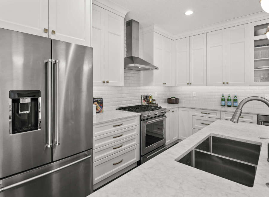 This stunning kitchen boasts sleek stainless steel appliances, including a French door refrigerator and a professional-grade gas range.