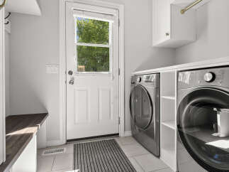 Discover this modern laundry room featuring a sleek LG ThinQ washer and dryer set, perfect for handling all your laundry needs.
