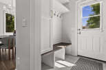 Step into this inviting entryway, featuring a built-in bench with ample storage and a convenient coat rack.