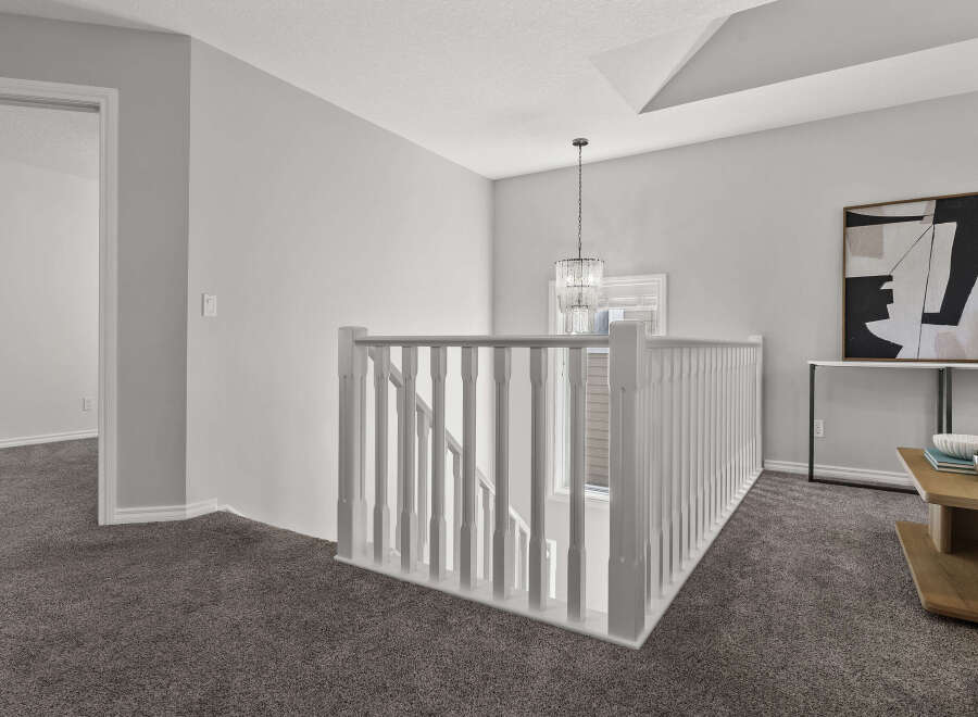 Step into this beautifully appointed hallway featuring plush grey carpeting and elegant white railings.