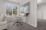 This bright and airy home office features a sleek glass-top desk with chrome legs, complemented by a comfortable upholstered desk chair.