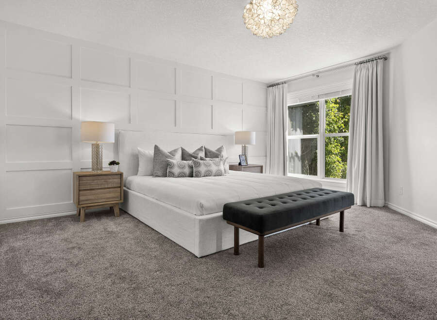 Experience luxurious comfort in this master bedroom, featuring elegant board and batten wall detailing and a plush upholstered bed.