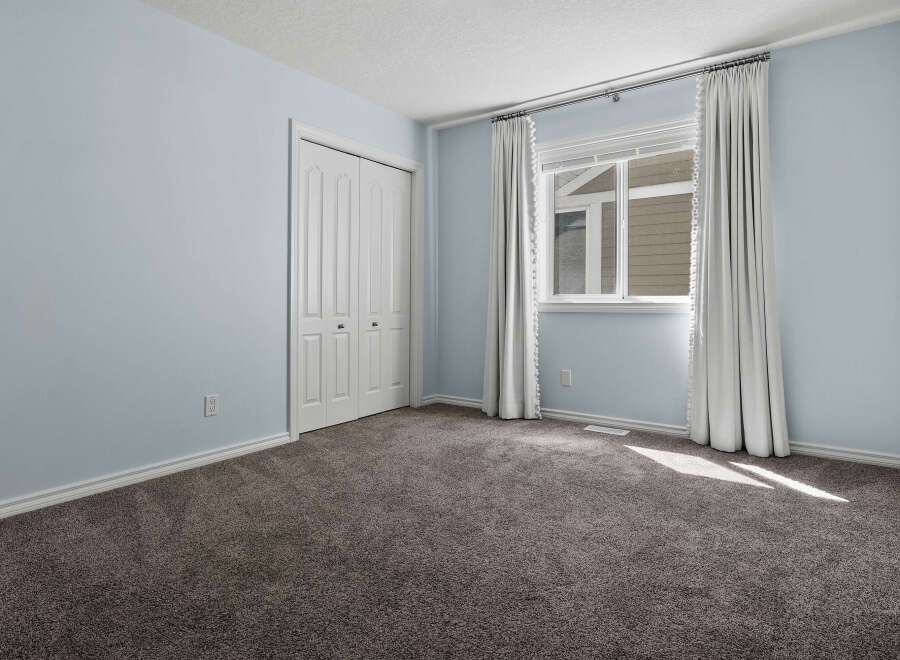 Step into this inviting bedroom, featuring a spacious closet and a large window that floods the room with natural light.