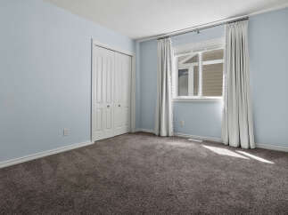 Step into this inviting bedroom, featuring a spacious closet and a large window that floods the room with natural light.