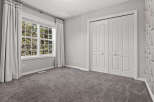 This bedroom features a large window with abundant natural light, complemented by elegant grey curtains.