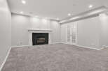 This spacious basement living area features a modern gas fireplace with a sleek black tile surround, perfect for cozy evenings.