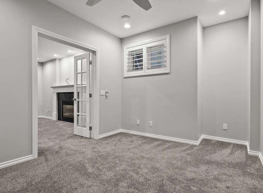 Step into this inviting living space featuring a cozy fireplace and elegant French doors that open to a well-appointed room.