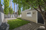 Discover this charming backyard oasis, featuring a lush green lawn perfect for relaxation and play.