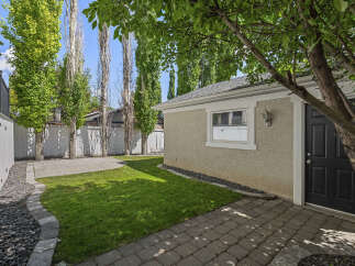 Discover this charming backyard oasis, featuring a lush green lawn perfect for relaxation and play.