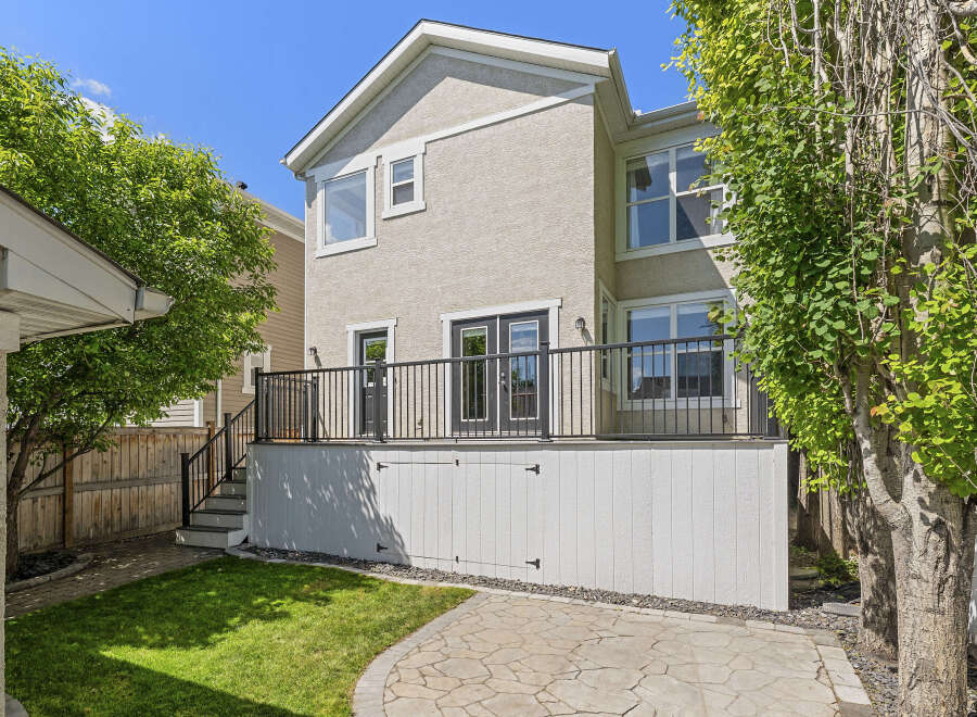 Enjoy outdoor living with this spacious backyard featuring a large deck perfect for entertaining and a lush green lawn.