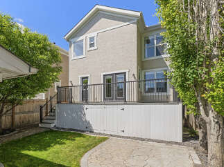 Enjoy outdoor living with this spacious backyard featuring a large deck perfect for entertaining and a lush green lawn.