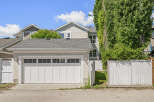 This charming property features a spacious double garage with a modern white door and multiple windows for natural light.