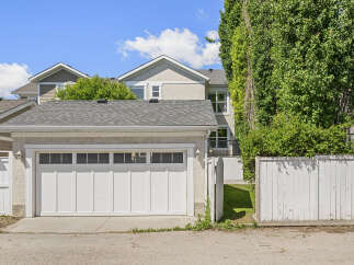 This charming property features a spacious double garage with a modern white door and multiple windows for natural light.