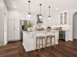 Experience the epitome of modern luxury in this stunning white kitchen, featuring sleek cabinetry, a spacious island with marble countertops, and elegant brass pendant lighting.