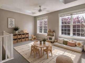 This charming playroom features a bright and airy atmosphere with large windows flooding the space with natural light.