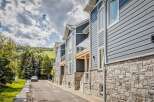 Discover modern living in this stunning townhouse complex, featuring sleek blue siding and elegant stone accents.