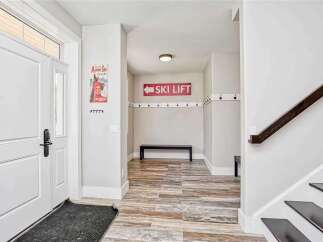 Step into this welcoming entryway featuring a stylish ski lift sign and ample coat hooks, perfect for a mountain retreat.