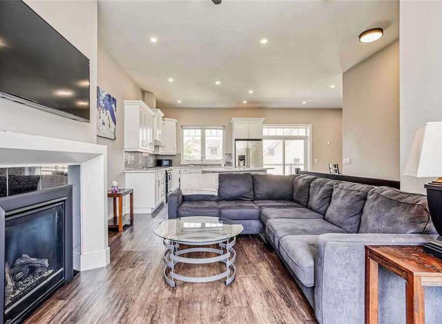 Experience modern living in this spacious open-concept home, featuring a sleek fireplace and a large sectional sofa perfect for gatherings.
