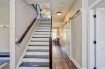 This modern home features a striking staircase with dark wood treads and white risers, complemented by a sleek glass and dark wood railing.