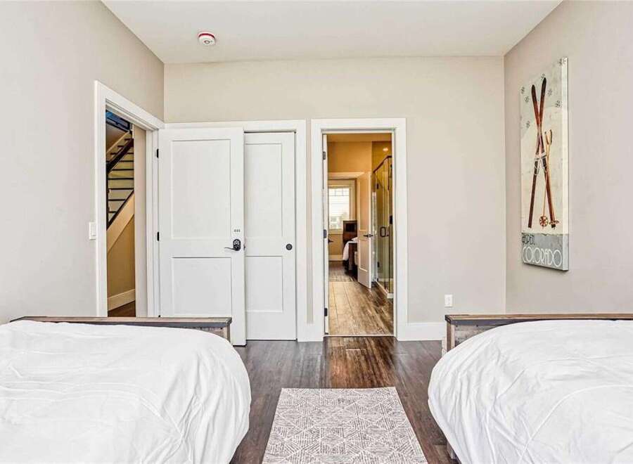 This inviting bedroom features two comfortable beds with crisp white linens, perfect for a restful night's sleep.