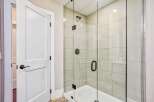 Step into this modern bathroom featuring a sleek glass-enclosed shower with elegant tilework and a rainfall showerhead.