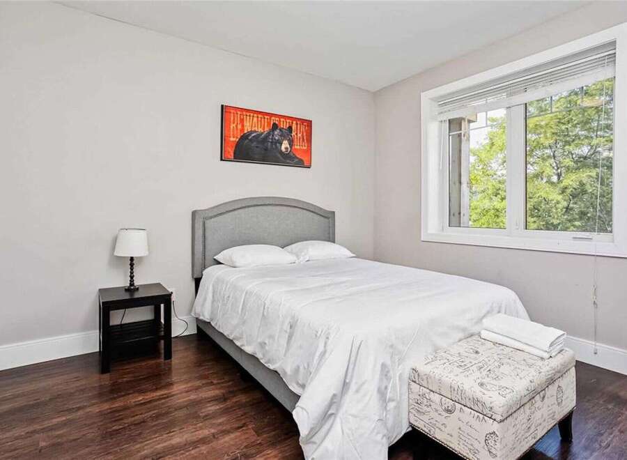 This charming bedroom features a comfortable queen-size bed with a stylish upholstered headboard, perfect for relaxation.