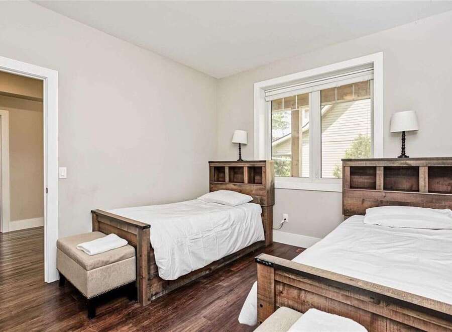 This charming bedroom features two twin beds with rustic wooden headboards, perfect for guests or children.