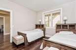 This charming bedroom features two twin beds with rustic wooden headboards, perfect for guests or children.