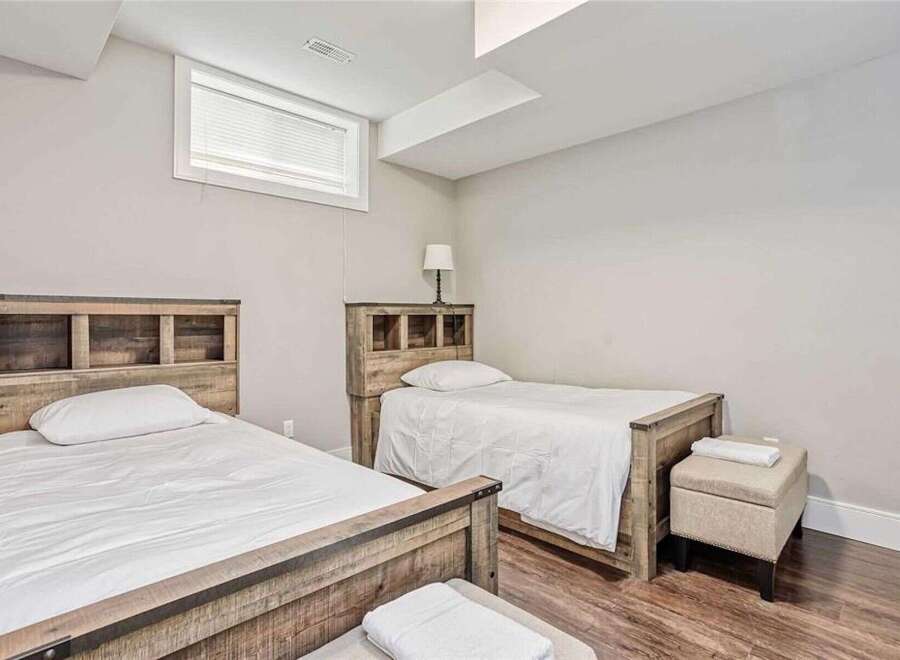 This charming bedroom features two twin beds with rustic wooden headboards, perfect for accommodating guests or family.