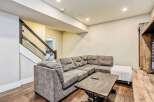 This modern living space features a spacious sectional sofa perfect for family gatherings, complemented by a rustic coffee table and a white ottoman.