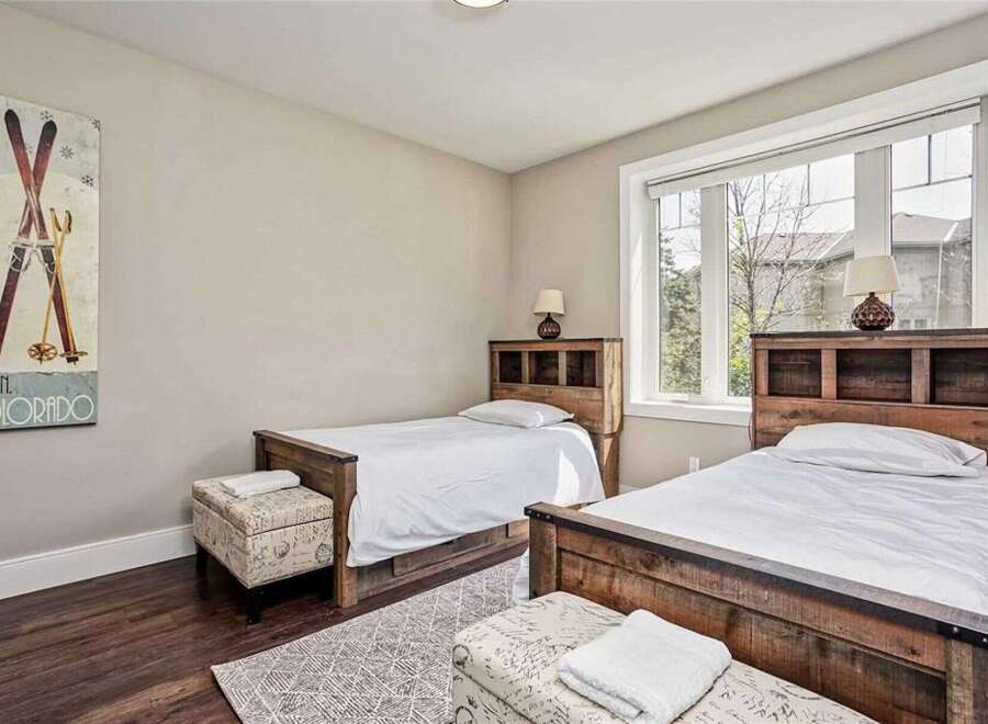 This charming bedroom features two twin beds with rustic wooden headboards, perfect for accommodating guests.