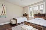 This charming bedroom features two twin beds with rustic wooden headboards, perfect for accommodating guests.