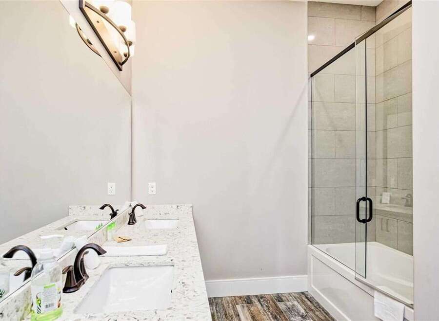 This modern bathroom features a spacious double vanity with granite countertops and elegant bronze fixtures, perfect for busy mornings.