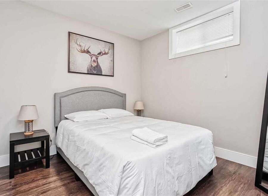 This cozy bedroom features a comfortable queen-size bed with crisp white linens, perfect for a restful night's sleep.