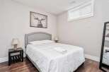 This cozy bedroom features a comfortable queen-size bed with crisp white linens, perfect for a restful night's sleep.