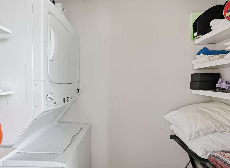 This laundry area features a stacked washer and dryer, perfect for maximizing space in your home.