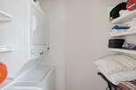 This laundry area features a stacked washer and dryer, perfect for maximizing space in your home.