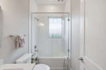 This modern bathroom features a sleek glass-enclosed shower and tub combination, perfect for a relaxing soak.