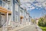 Discover modern living in this stunning townhouse complex, featuring elegant blue siding and charming stone accents.