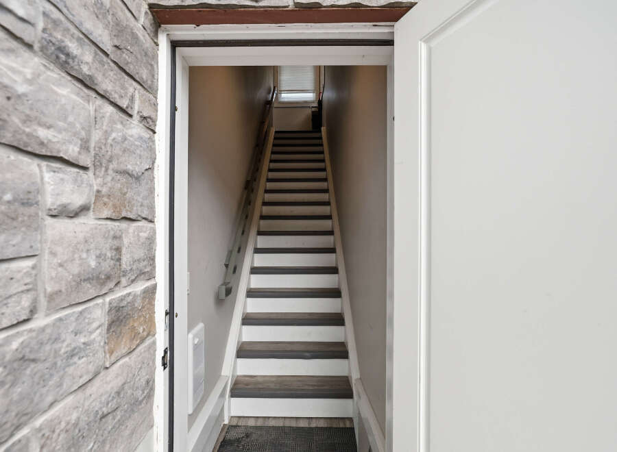 Step into this charming property and be greeted by a well-lit staircase leading to the upper levels.