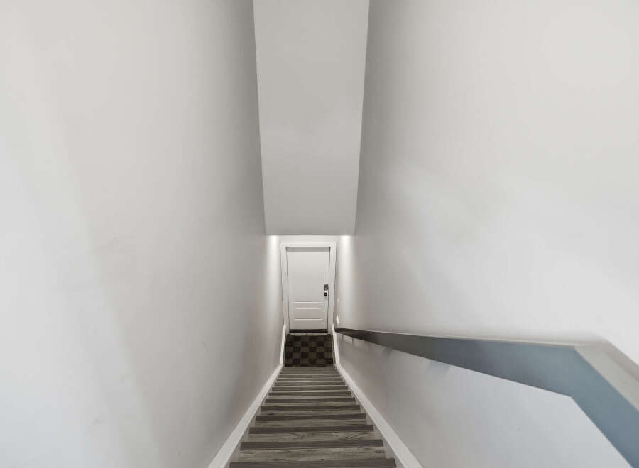 Ascend to the upper level of this home via a modern staircase featuring sleek wood-look treads and a minimalist handrail.