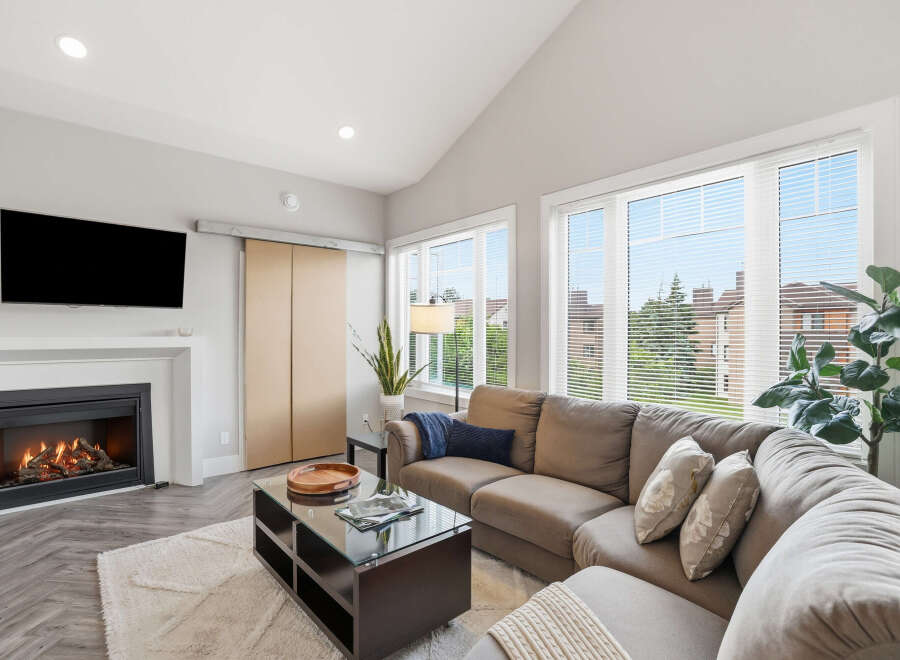 Experience modern living in this spacious living room, featuring a cozy gas fireplace and a large sectional sofa perfect for gatherings.