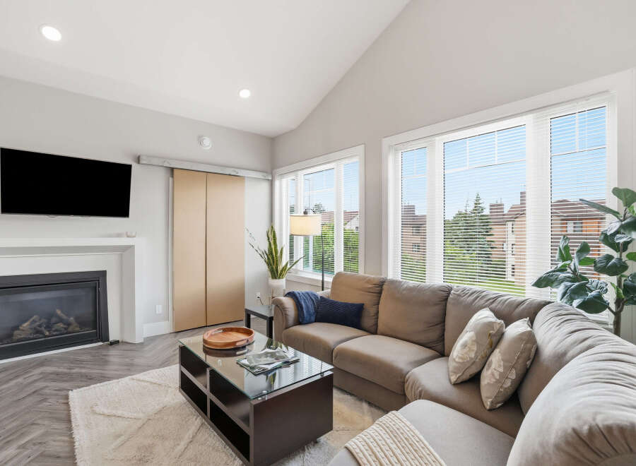 Experience modern living in this spacious living room, featuring a cozy gas fireplace and a large sectional sofa perfect for gatherings.