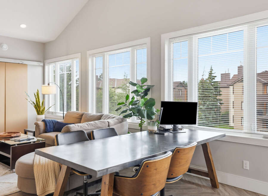 This modern living space features a comfortable sofa and a stylish desk area, perfect for a home office setup.