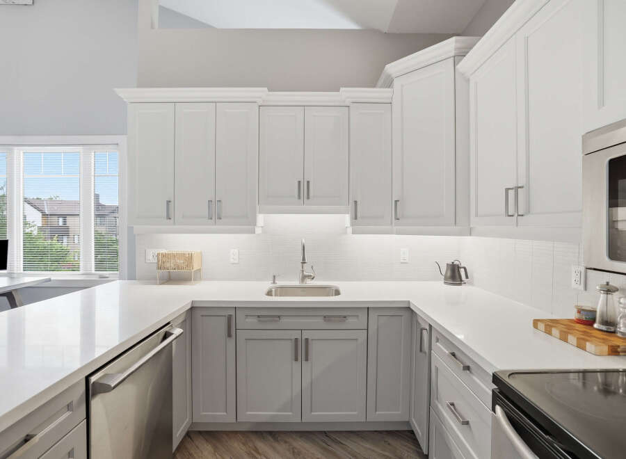 Experience modern living in this stunning kitchen featuring sleek white cabinetry and a spacious quartz countertop.
