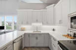Experience modern living in this stunning kitchen featuring sleek white cabinetry and a spacious quartz countertop.