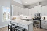 Experience modern living in this stunning kitchen featuring sleek white cabinetry and a spacious quartz countertop island perfect for entertaining.