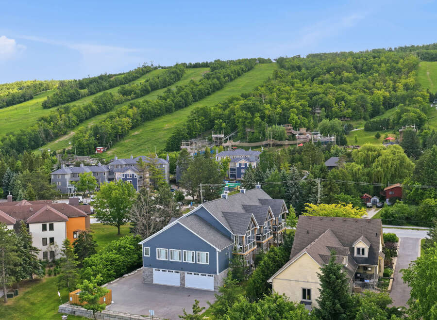 Discover this stunning property nestled against a lush green hillside, offering breathtaking views and a serene atmosphere.