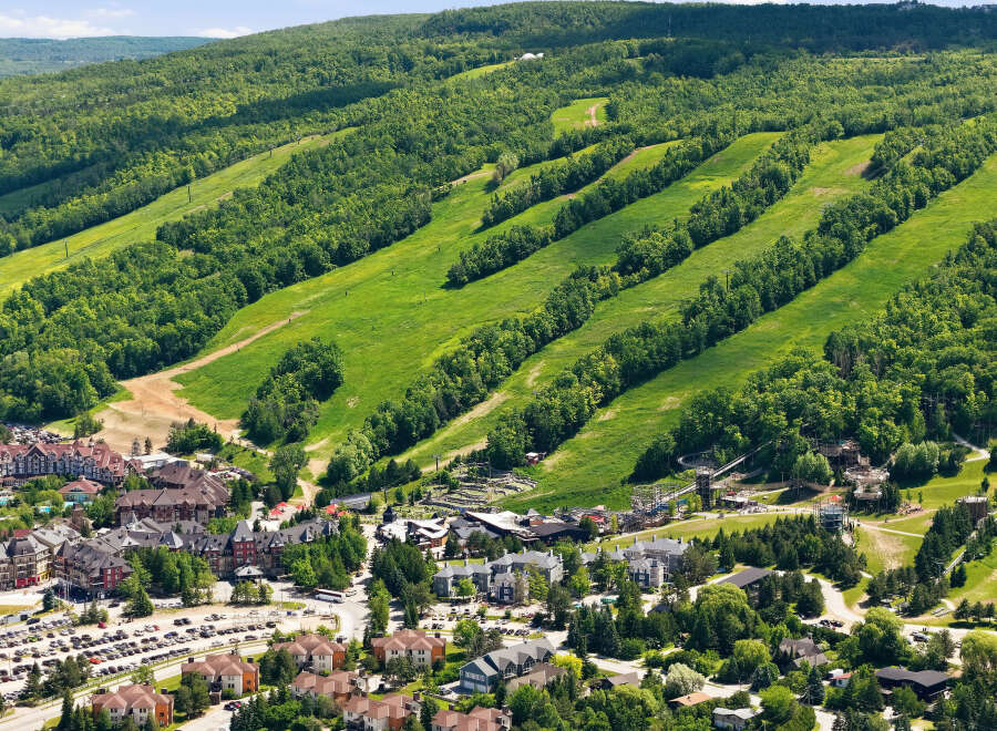 Discover this stunning mountain resort offering a vibrant village with charming architecture and ample parking, nestled at the base of lush, tree-lined ski slopes.